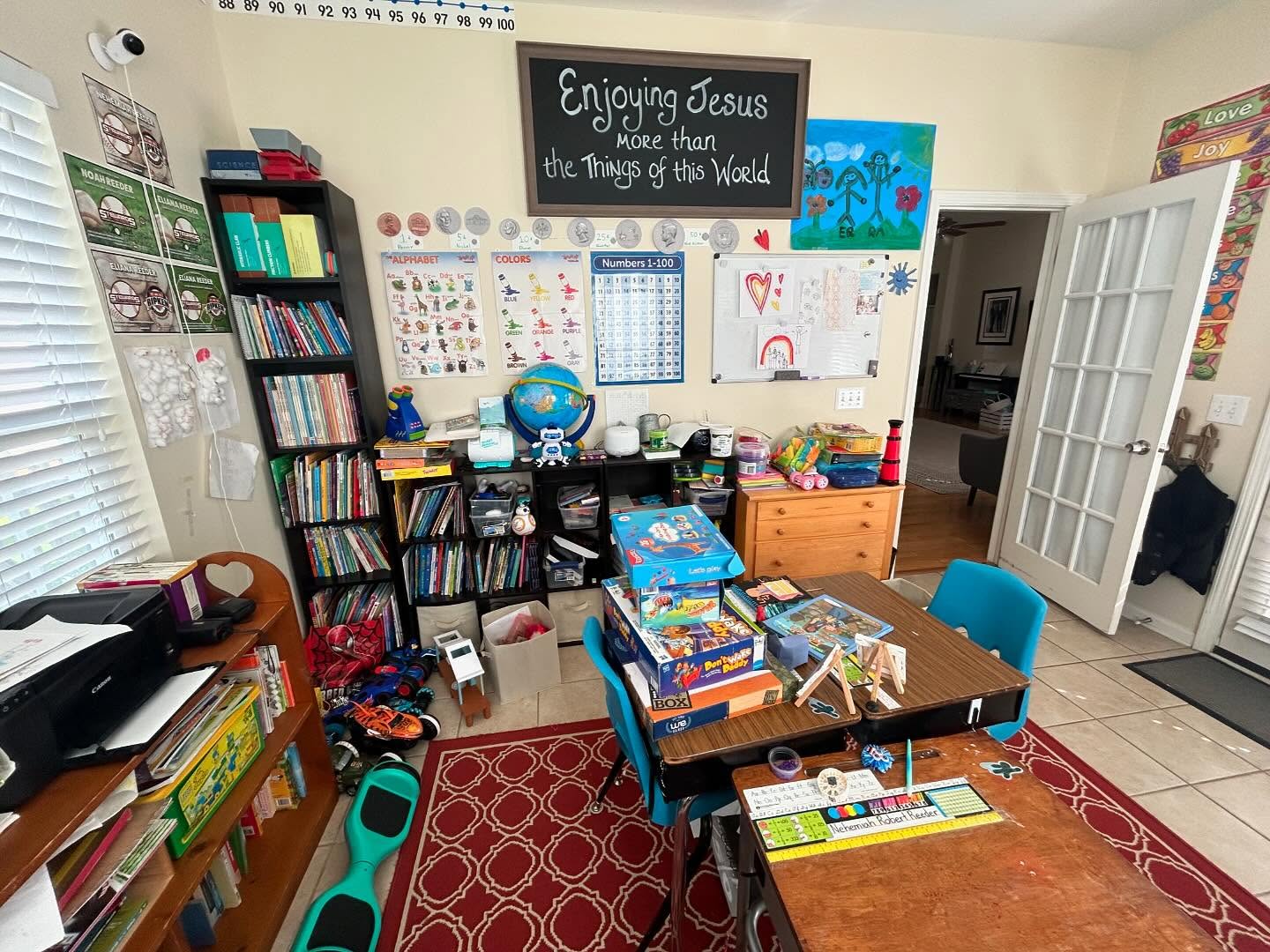 Cluttered homeschool room before professional organizing by Simply Stored in Hickory NC — overflowing bookshelves, toys, and supplies
